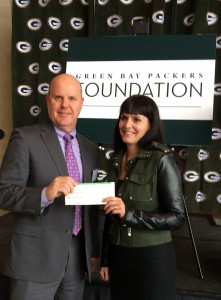Pat Heier, from The Women’s Community Board, and Jane Graham Jennings receive a grant check from The Green Bay Packers Foundation
